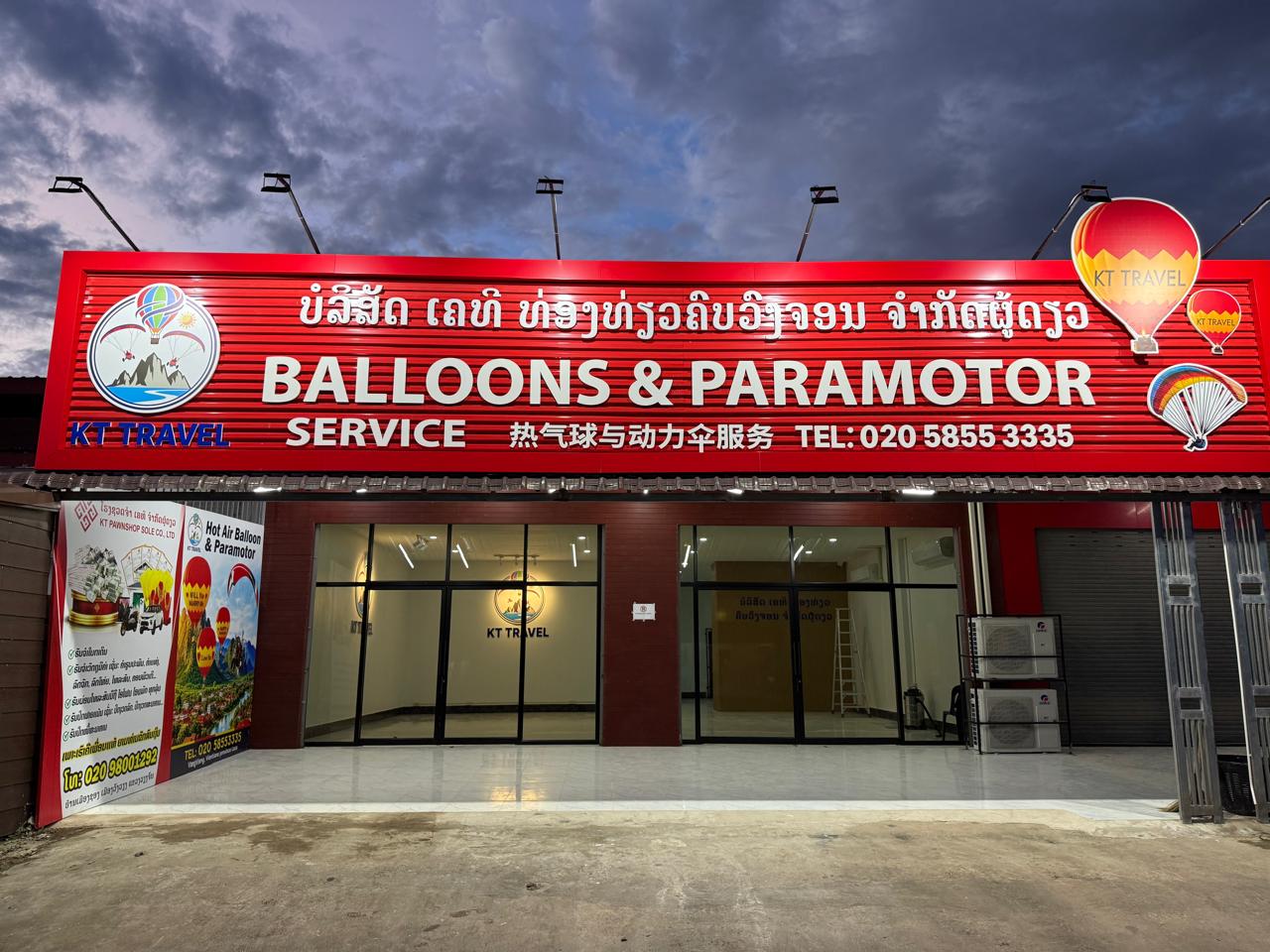 The KT Travel shop in Vang Vieng, with the red Balloons & Paramotor Service sign